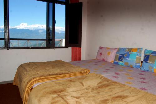 a room with two beds and a window with mountains at Snow View Guest House Kausani & homestay in Kausani