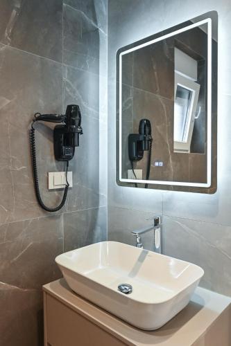 a bathroom with a sink and a mirror at Aparthotel OLIVE with jacuzzi and breakfast in Novalja
