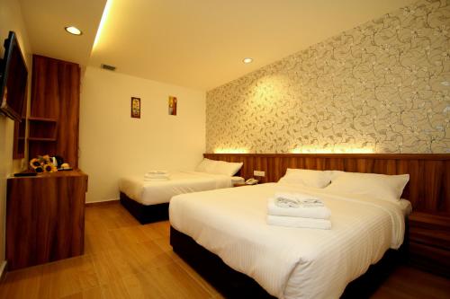 a hotel room with two beds with white sheets at Century Inn Hotel in Cukai