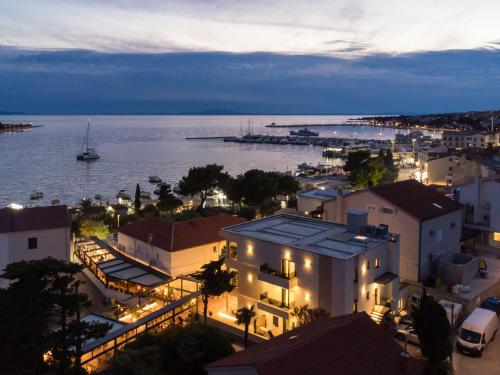 a view of a city at night with the water at Aparthotel OLIVE with jacuzzi and breakfast in Novalja