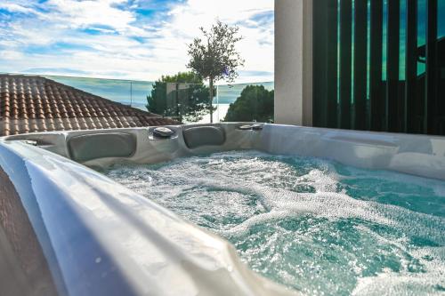 a jacuzzi hot tub with water in a backyard at Aparthotel OLIVE with jacuzzi and breakfast in Novalja