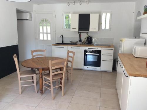 une cuisine avec une table en bois et une table et des chaises dans l'établissement maison en provence, à Auriol