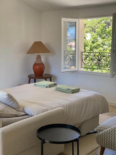 une chambre avec un lit avec une table et une fenêtre dans l'établissement Villa Gyptis - Calanques, Calme & Spacieux, à Marseille