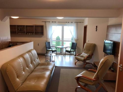 un salon avec un canapé, des fauteuils et une table dans l'établissement Sunset by the lake, à Siófok