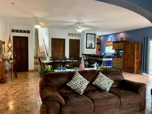 ein Wohnzimmer mit einem braunen Sofa und einer Küche in der Unterkunft Villa Papaya #2 spacious 2 bedroom beach villa in San Pancho in San Francisco