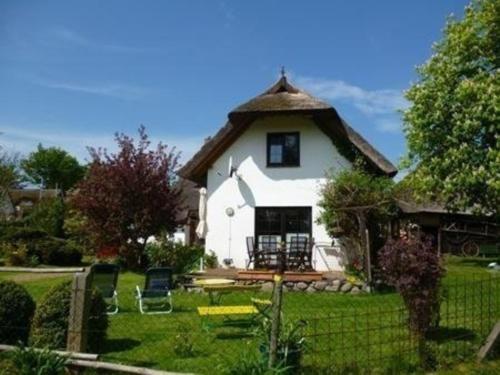a small white house with a thatched roof at Schönes Ferienhaus in Althagen mit Terrasse und Grill in Ahrenshoop