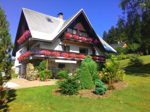 a house with flowers on the side of it at Apartmán Šírovi in Benecko