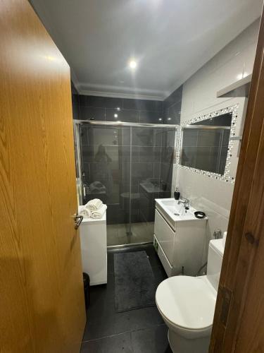 a bathroom with a toilet and a sink and a shower at Casa Verão Azul in Monte Gordo