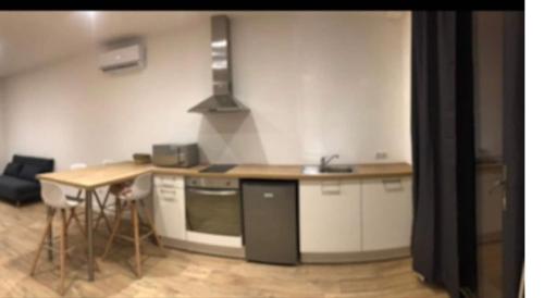 - une cuisine avec un comptoir et une cuisinière four supérieur dans l'établissement Location très agréable T2 neuf corte, à Corte