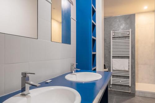 La salle de bains est pourvue de 2 lavabos et d'un comptoir bleu. dans l'établissement Montmartre - Sacré-Coeur l Spacious - Luminous, à Paris