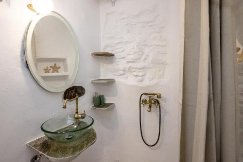 a bathroom with a sink and a mirror at Adamma Tinos in Kékhros