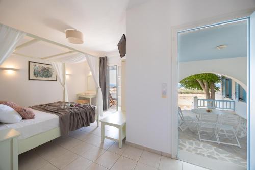 een slaapkamer met een bed en uitzicht op een patio bij Villa Porto Rondo in Agios Prokopios