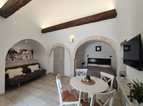 a bedroom and a living room with a bed and a table at Trullo al vicoletto al civico 10, civico 8, civico 7 in Alberobello