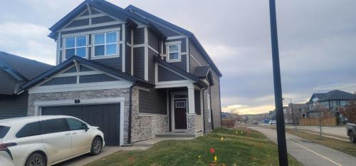 a white car parked in front of a house at A Cozy home away from home at South East Calgary in Calgary