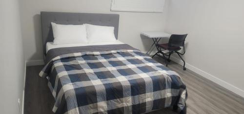 カルガリーにあるA Cozy home away from home at South East Calgaryのベッドと椅子と机のある寝室