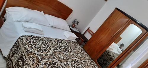 a bedroom with a bed with a wooden headboard and a mirror at Casa vacanze di Palazzo la Loggia in Barisciano