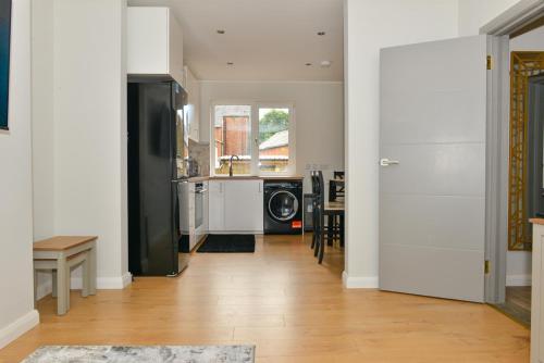 cocina con nevera negra y mesa en Esterville Apartments 1 and 2 bedrooms hot tub availability, en Belfast