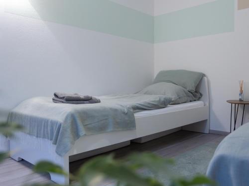 a white bed in a white room with a bedskirtspectspectspects at Stilvolle Wohnung in Aachen Brand mit Terrasse in Aachen