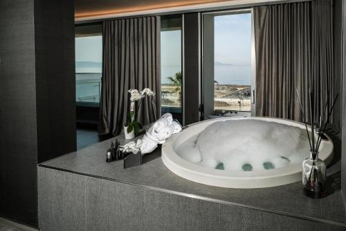 a bathroom with a tub with a view of the ocean at Hotel & Resort Tre Fontane Luxury in Portici