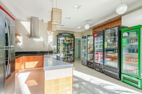 a grocery store aisle with refrigerators and drinks at Lifespace 7 Setembro - Apartamentos UROOMS in Curitiba
