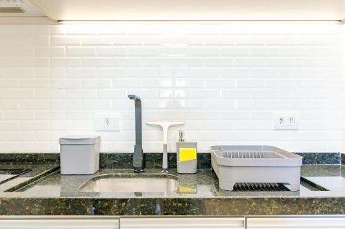 a kitchen counter with a sink and a faucet at Lifespace 7 Setembro - Apartamentos UROOMS in Curitiba