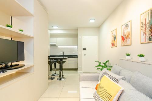 a living room with a couch and a flat screen tv at Lifespace 7 Setembro - Apartamentos UROOMS in Curitiba