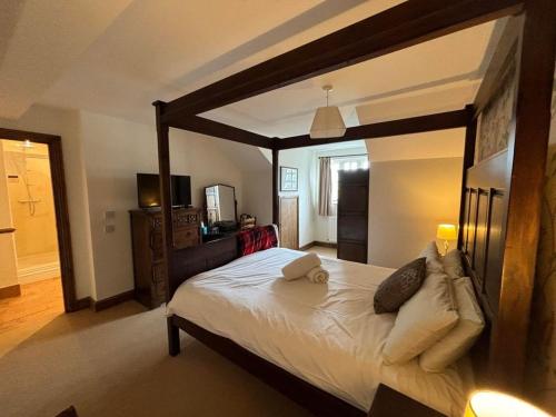 a bedroom with a large wooden canopy bed with pillows at True Lovers Knot in Blandford Forum