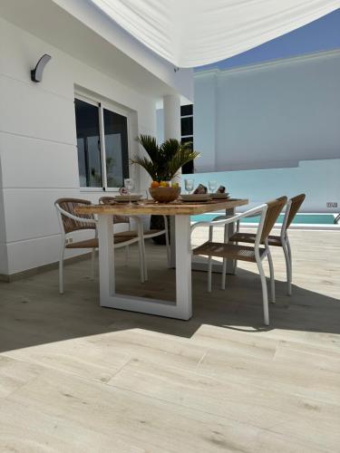 a dining table and chairs with a plant on it at Casa Mer in Tías