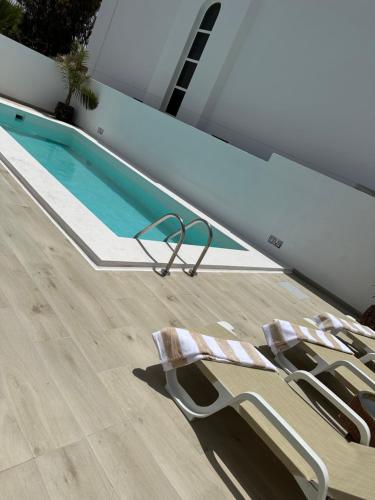 two lounge chairs sitting next to a swimming pool at Casa Mer in Tías