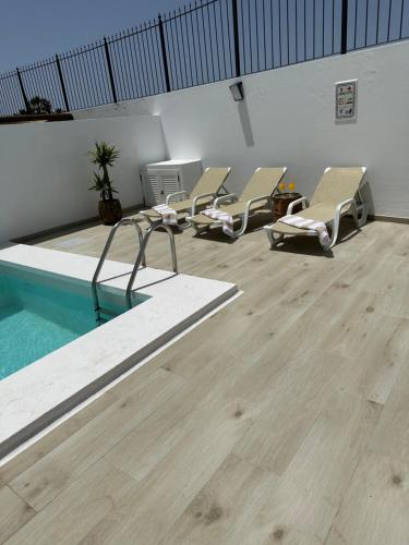 a room with chairs and a swimming pool at Casa Mer in Tías
