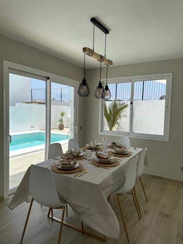 a white dining room with a table and a view of the ocean at Casa Mer in Tías