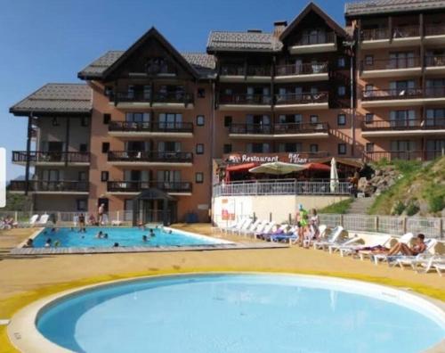 un hôtel avec une piscine et un complexe dans l'établissement Appartement aux pieds des pistes, à Valmeinier