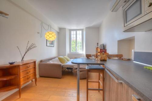 une cuisine et un salon avec une table et un canapé dans l'établissement 4 - Cosy studio old Antibes, à Antibes