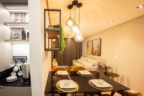 a kitchen and living room with a table and chairs at Apto 306 Inn com vista Parque Una e garagem in Pelotas