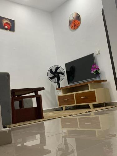 ein Wohnzimmer mit Fernseher und Tisch in der Unterkunft Résidence in Abidjan