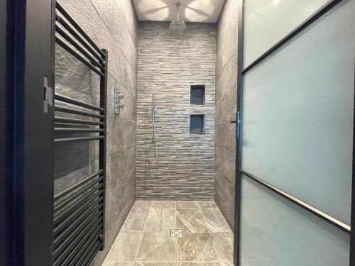 a bathroom with a walk in shower and a glass door at Henrys in St Ives