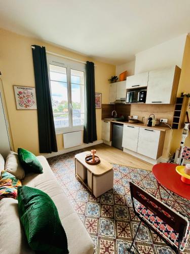 un salon avec un canapé et une table dans l'établissement Au cœur de la ville, 2 pièces, à Trouville-sur-Mer