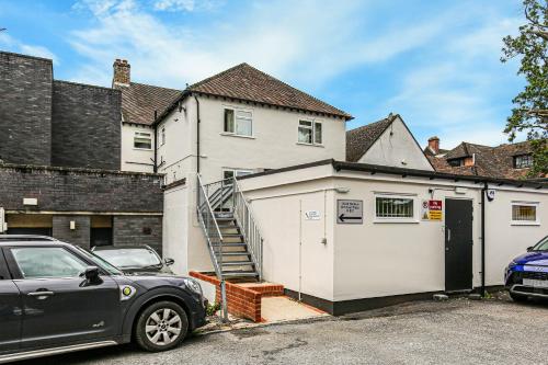 a car parked in front of a house with a garage at Oxted High St in Titsey