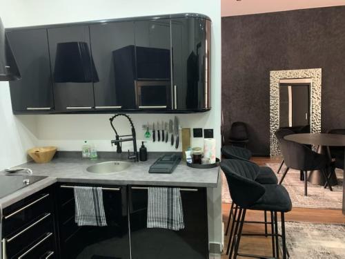 - une cuisine avec un évier, une table et des chaises dans l'établissement Paris Incredible Olympic Nest, à Paris