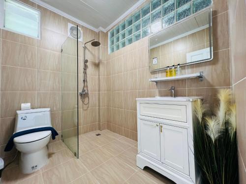 a bathroom with a toilet and a glass shower at Moonlight Panorama Seaview House by RESAVA in Surin Beach
