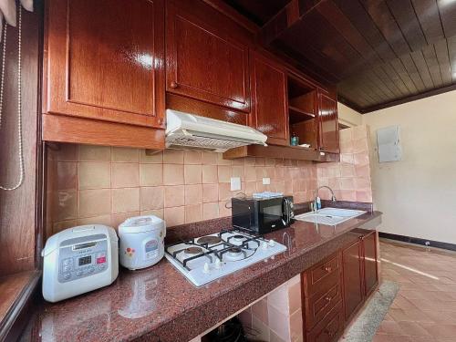 a kitchen with a counter with a stove and a microwave at Moonlight Panorama Seaview House by RESAVA in Surin Beach