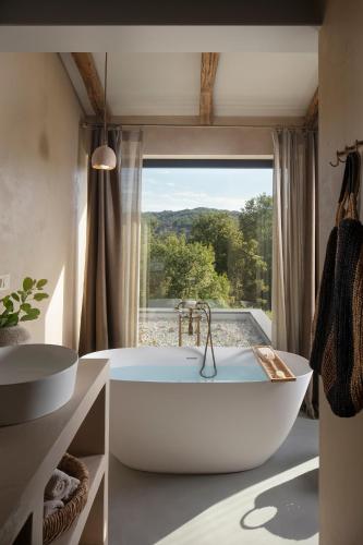 a bathroom with a tub and a large window at Villa Bagnoli in Boljun