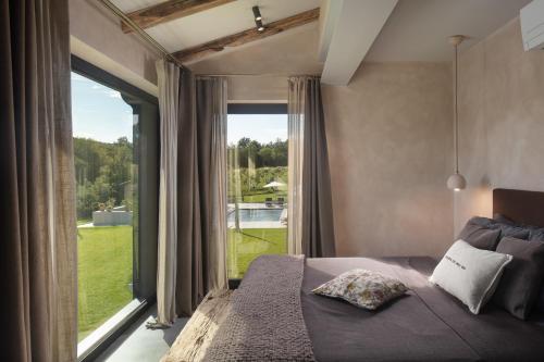 Un dormitorio con una cama y una ventana grande. en Villa Bagnoli, en Boljun