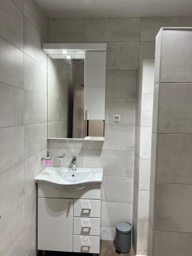 Apartmani Mareta في بتروفاتس نا مورو: حمام أبيض مع حوض ومرآة