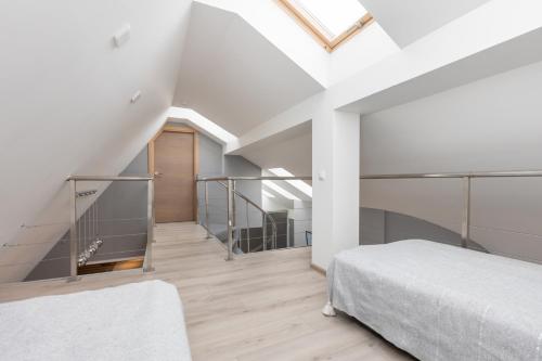 a bedroom with white walls and a skylight at Penthouse Apartment with Terrace in Rīga