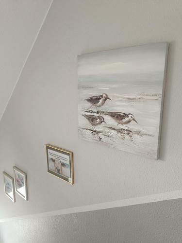 a picture of two birds on a wall at Marschblick in Südermarsch
