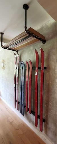 une rangée de skis appuyés contre un mur dans l'établissement Un petit nid au pied des pistes, à Bagnères-de-Bigorre