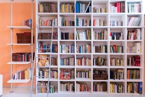 a book shelf filled with lots of books at Camera privata con cucina in Nettuno