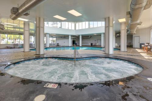 an empty pool in a large building with a swimming pool at Gulf Shores Escape Resort Condo with Balcony in Gulf Highlands