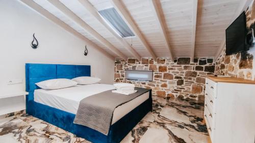 a bedroom with a king sized bed and a tv at Evaggelia's Stone Suites in Skala Marion